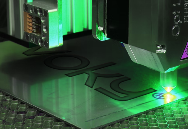 Voky-logotypen lasergraverad p&aring; en metallpl&aring;t.