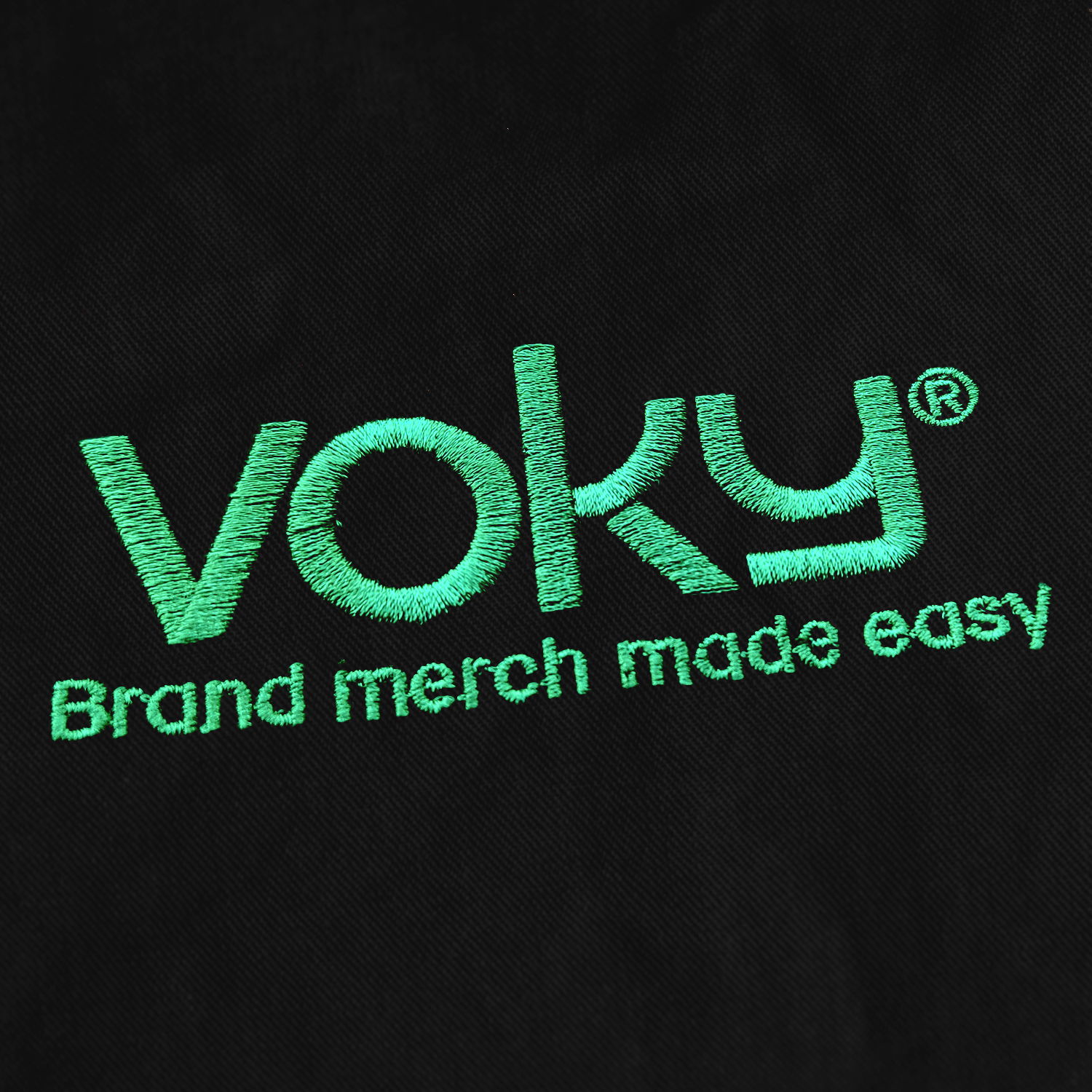 Voky-logga med sloganen "Brand merch made easy" broderad på svart textil