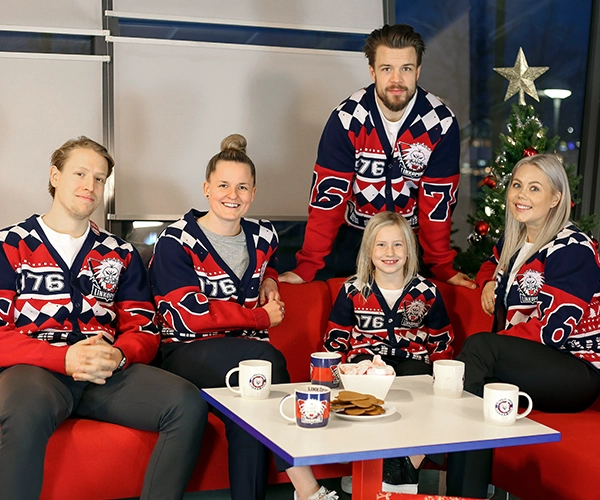 Fem personer som bär Linköpings Hockey Clubs tröjor med jultema
